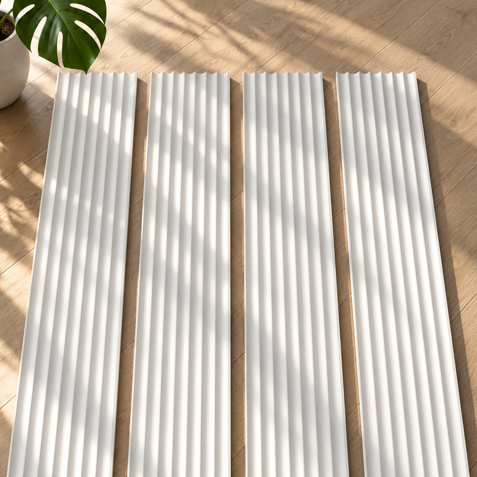 Four long white ribbed decorative panels laid out on a light wood floor, with a potted plant casting leaf shadows across the surface.