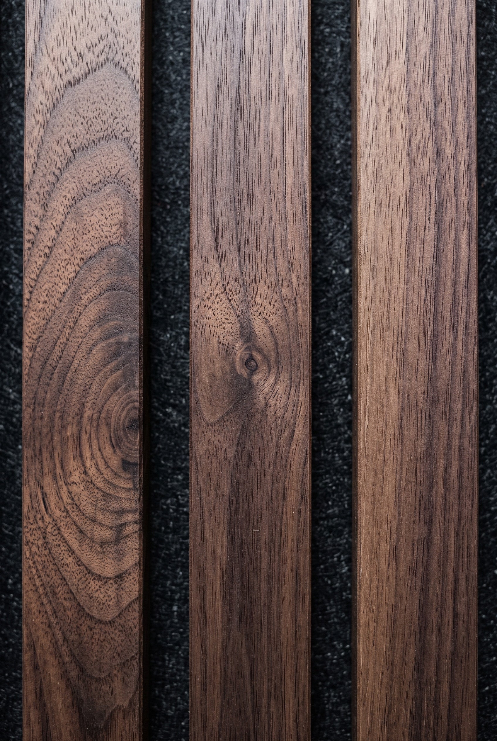 Three vertical dark brown wood planks with visible grain patterns, arranged side-by-side against a dark textured background.
