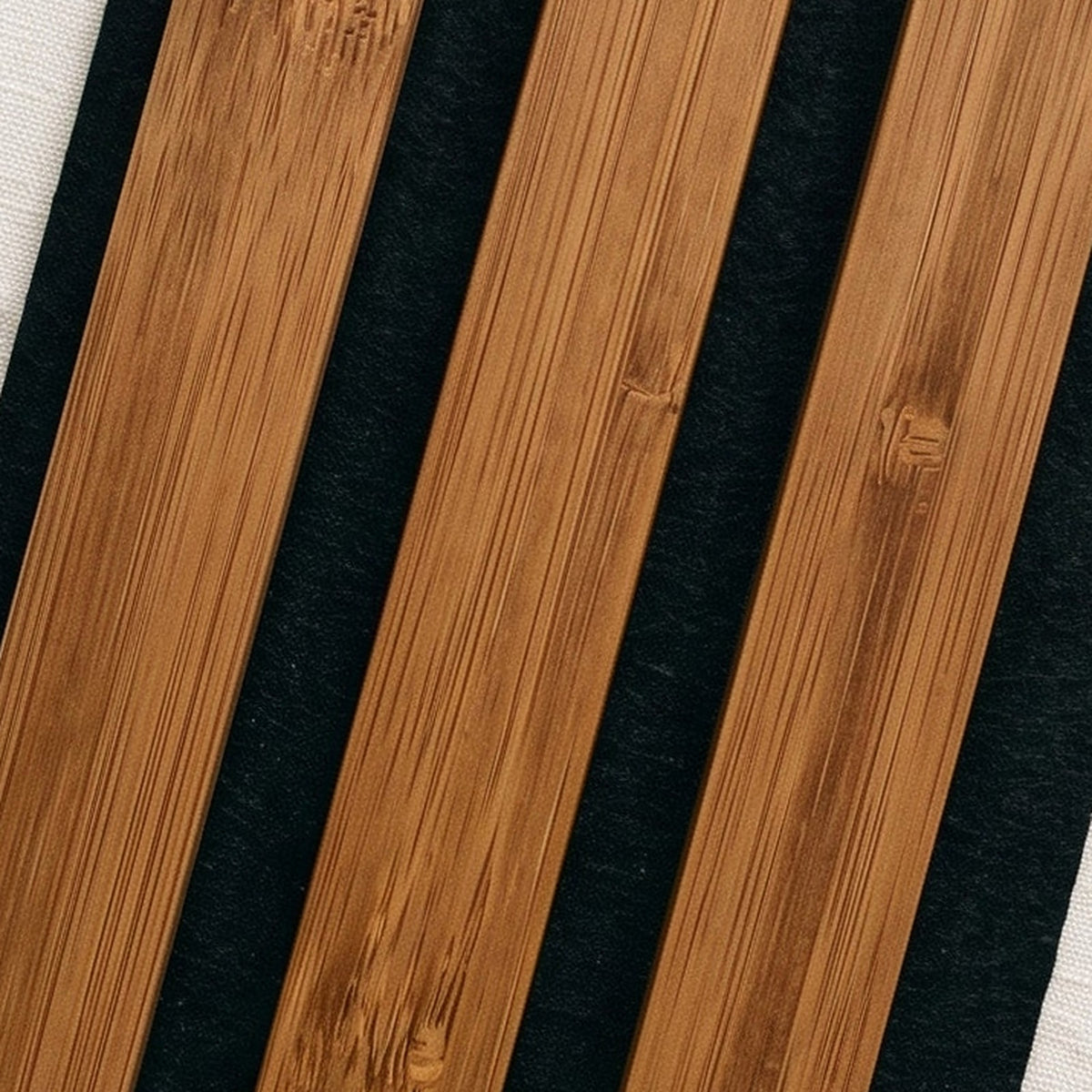 Close-up of Solid Bamboo slats in Medium Brown on black felt, showing the bamboo grain